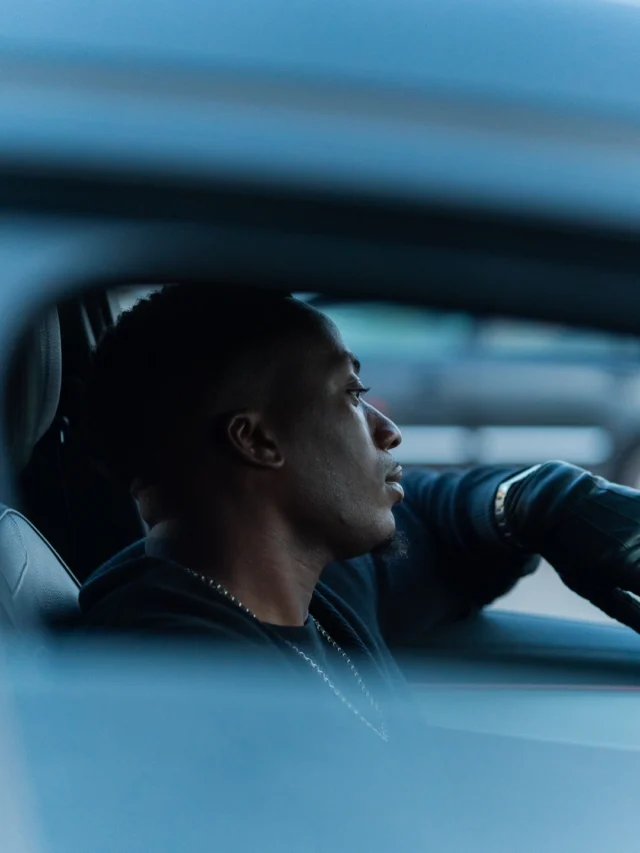 Tayo seated in a car, cinematic blue tones